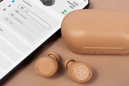JLab HEAR earbuds in beige, next to a phone with the JLab app